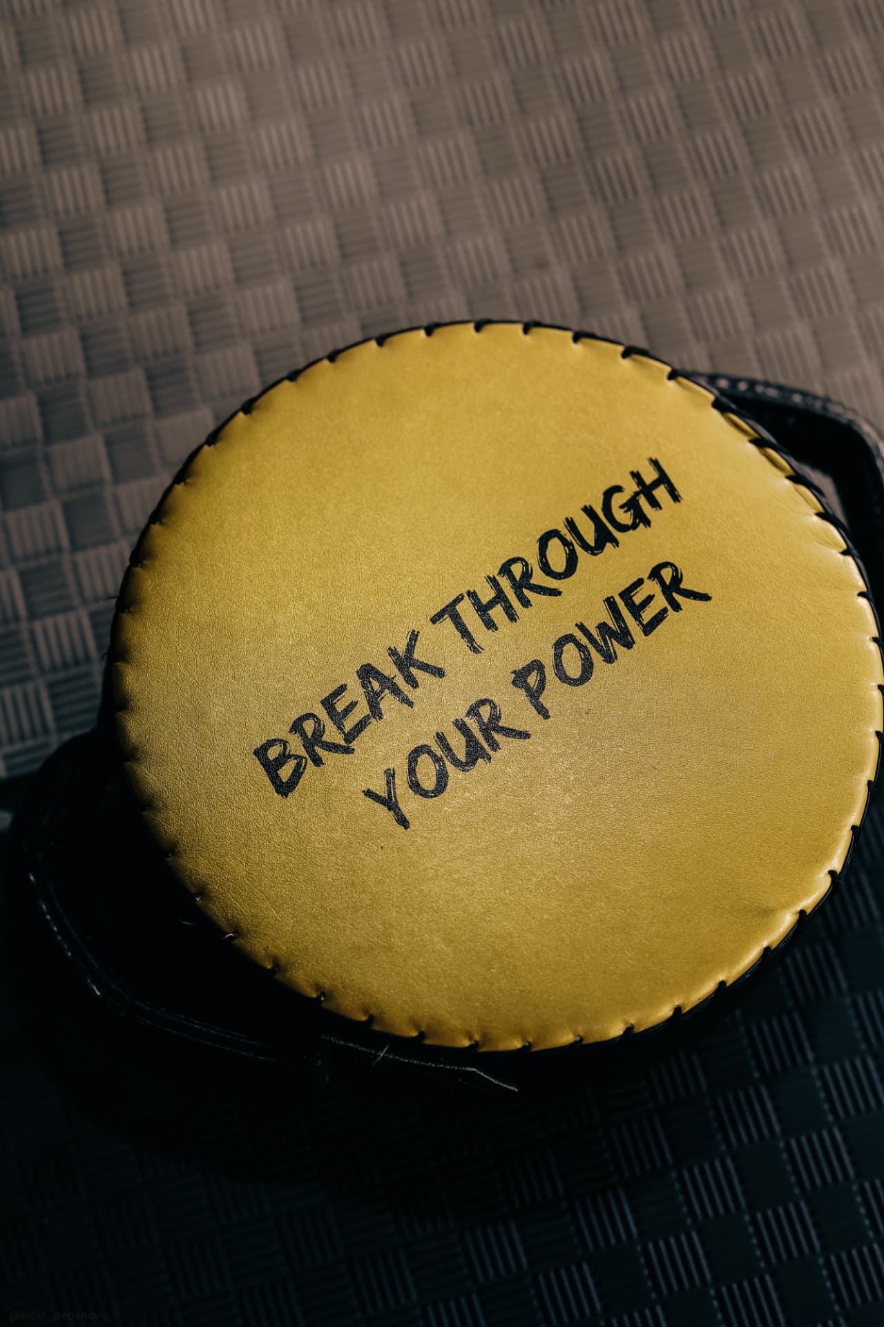 A gold pad printed with Break Through Your Power lying on the mats