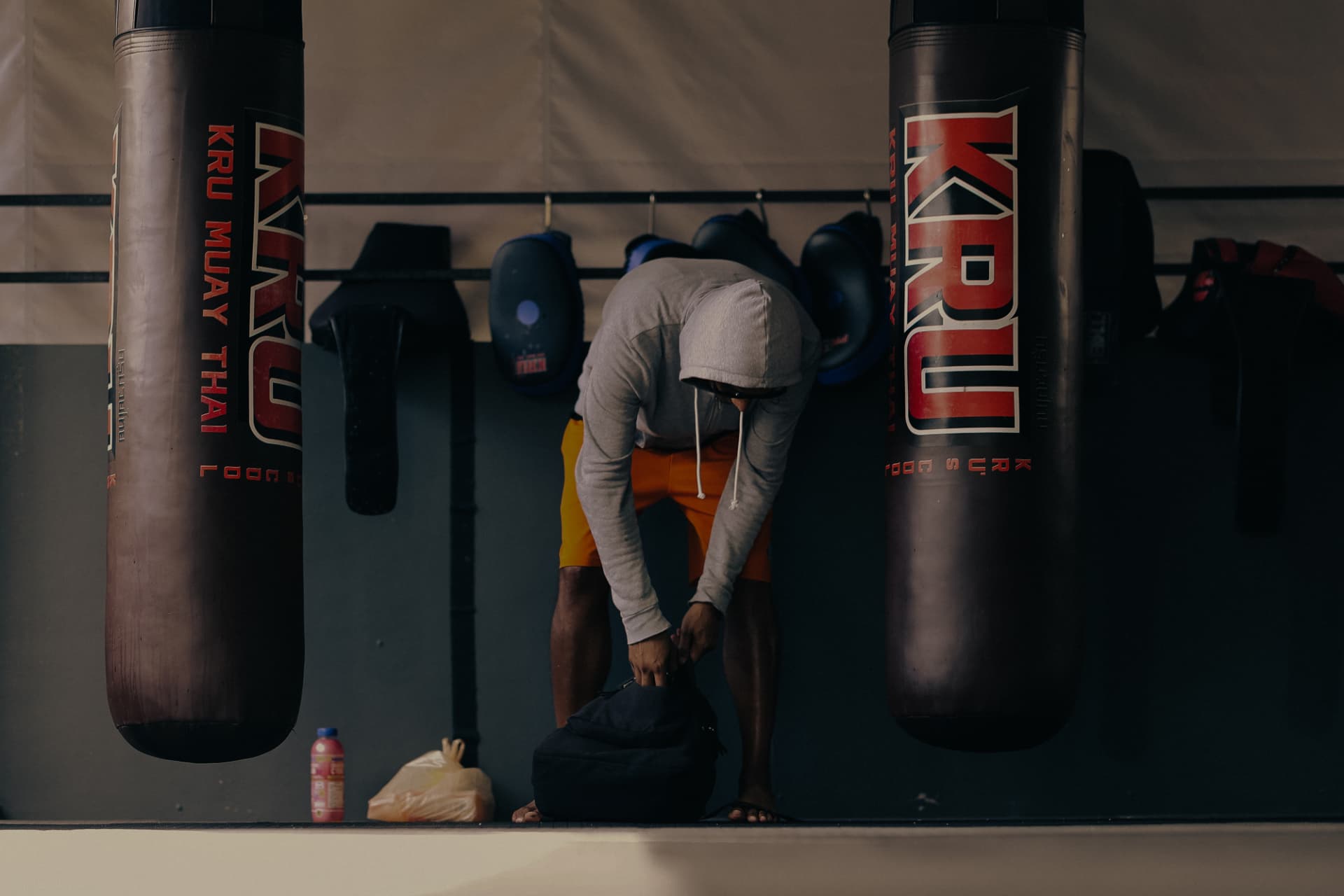 A student bent over catching breath between two KRU heavy bags