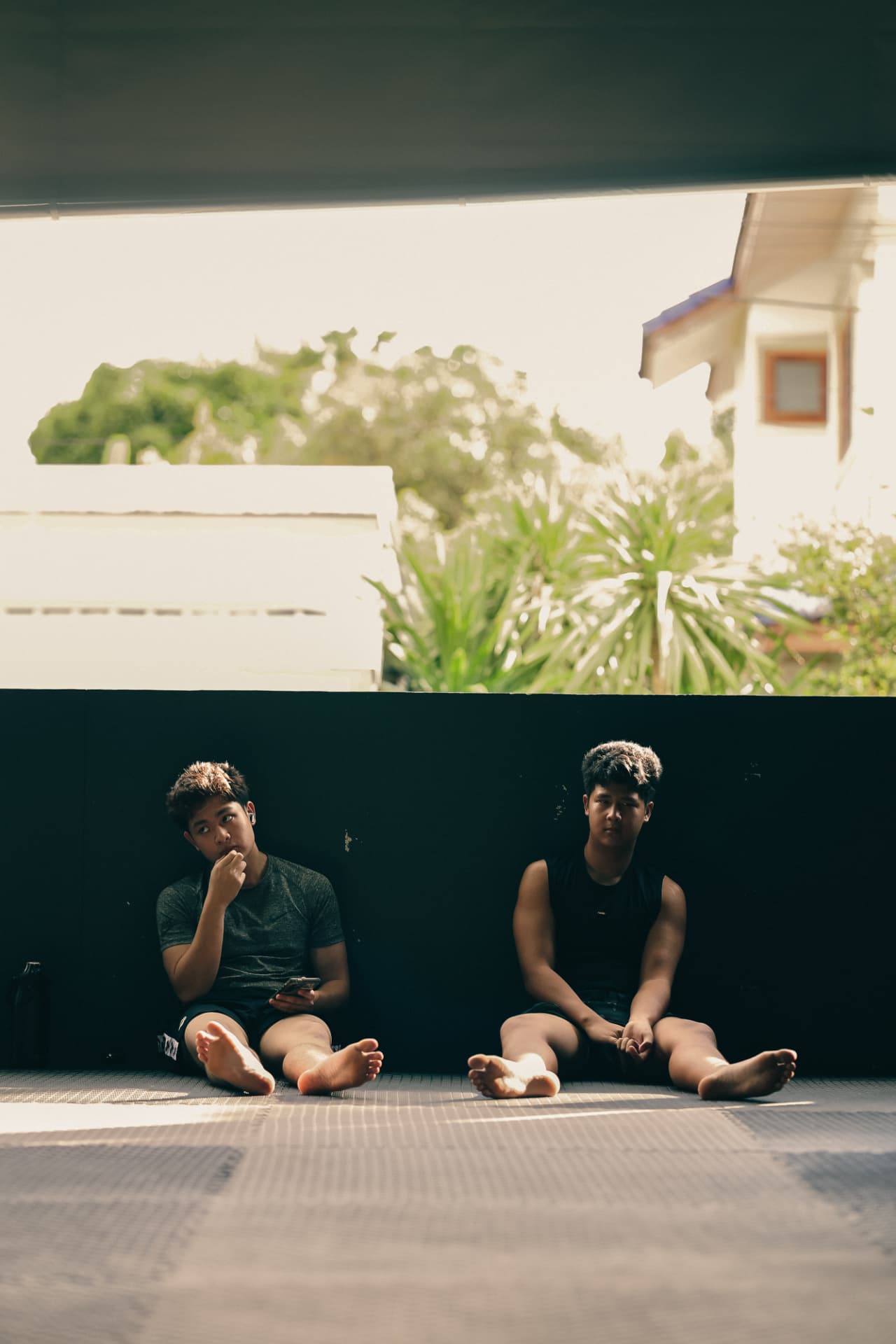 Two young fighters resting on the mats after training