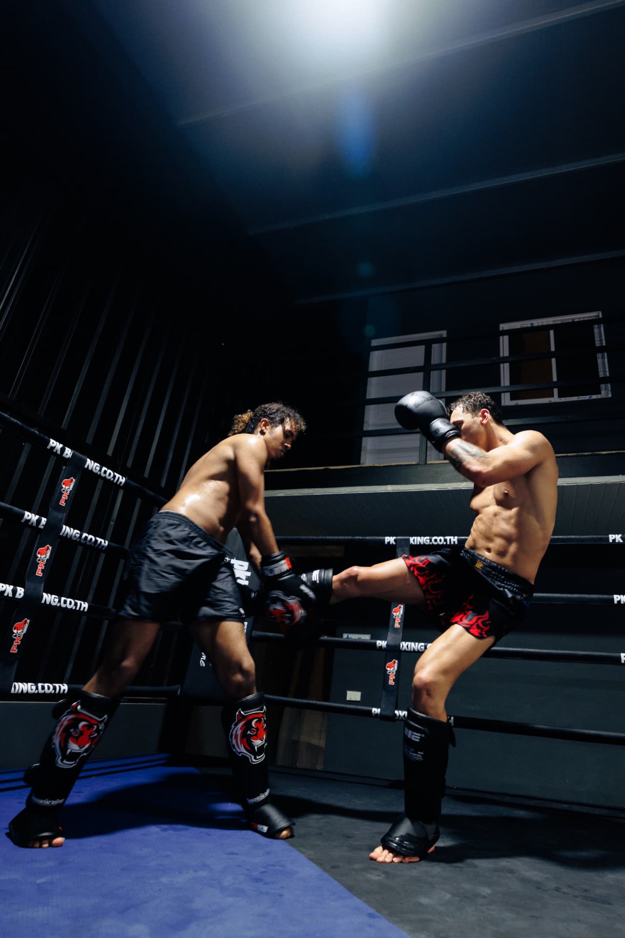 Two men sparring in the ring at Kru Muay Thai Gym